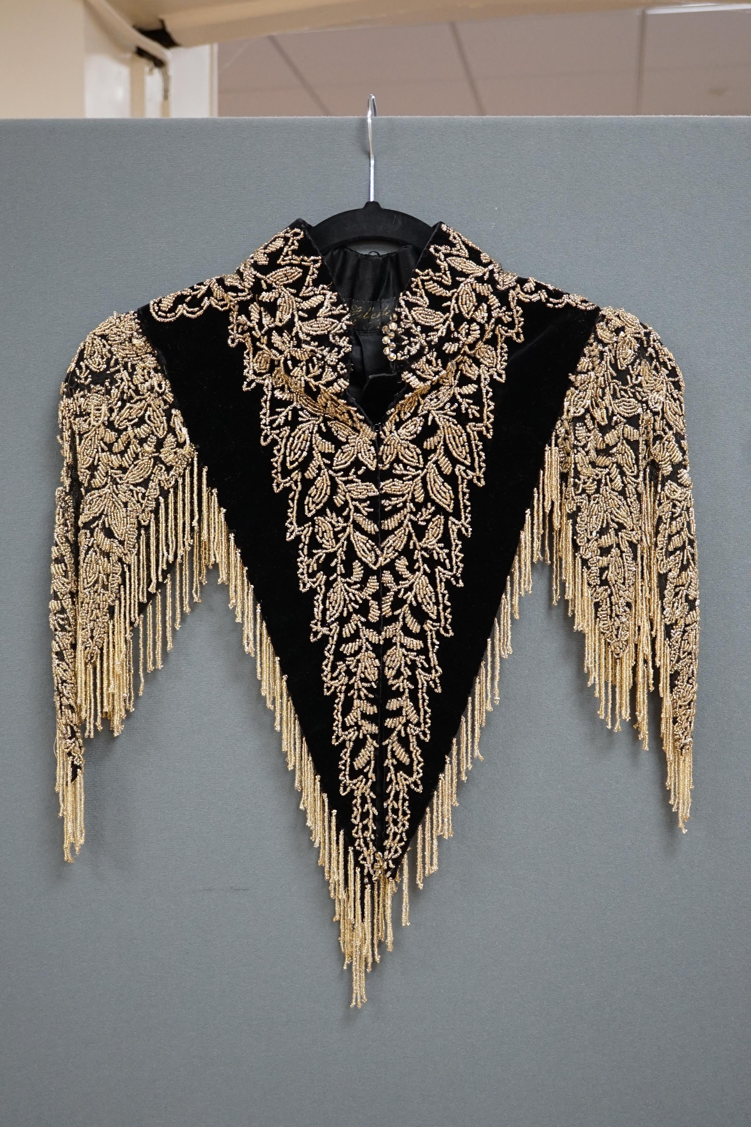 An Edwardian French black velvet and elaborately beaded evening over collar, with makers label, ‘Fillet’, designed with a high collar, front and back panels, all heavily bead worked in an intricate floral design, attache